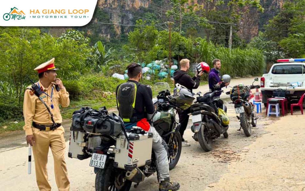Traffic officer at a roadside check with riders on the Ha Giang Loop