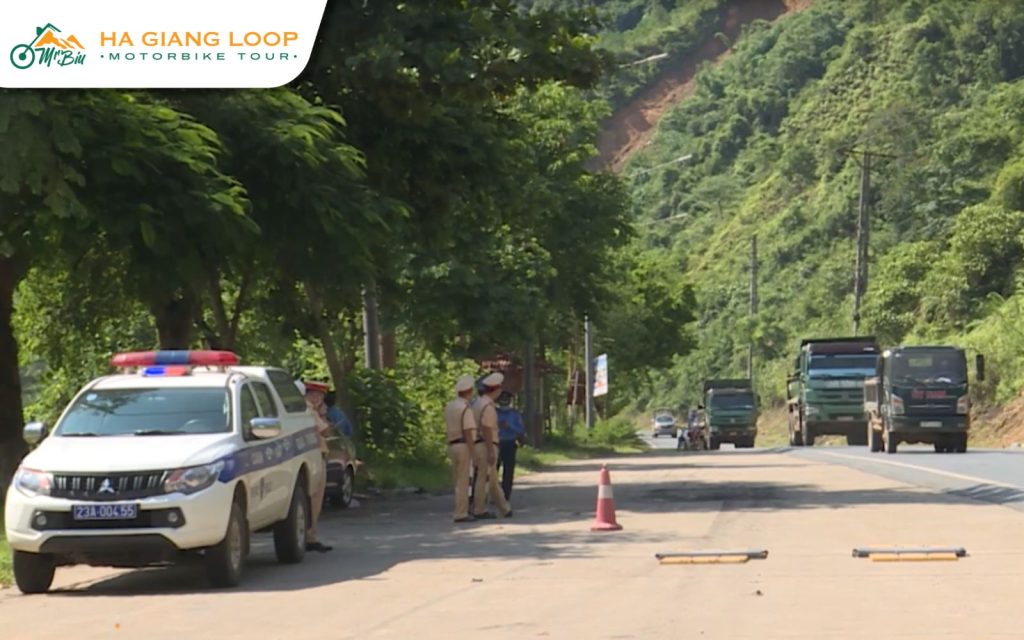 Police car and officers at a roadside checkpoint on the Ha Giang Loop