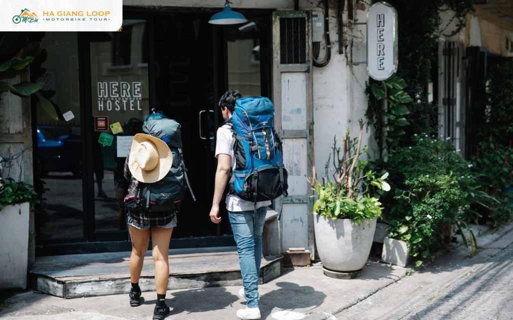 Two backpackers with large packs arriving at a hostel