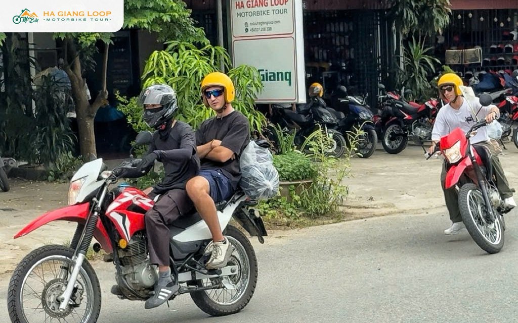 Easy rider guest sitting behind a local driver on a Mr. Biu motorbike