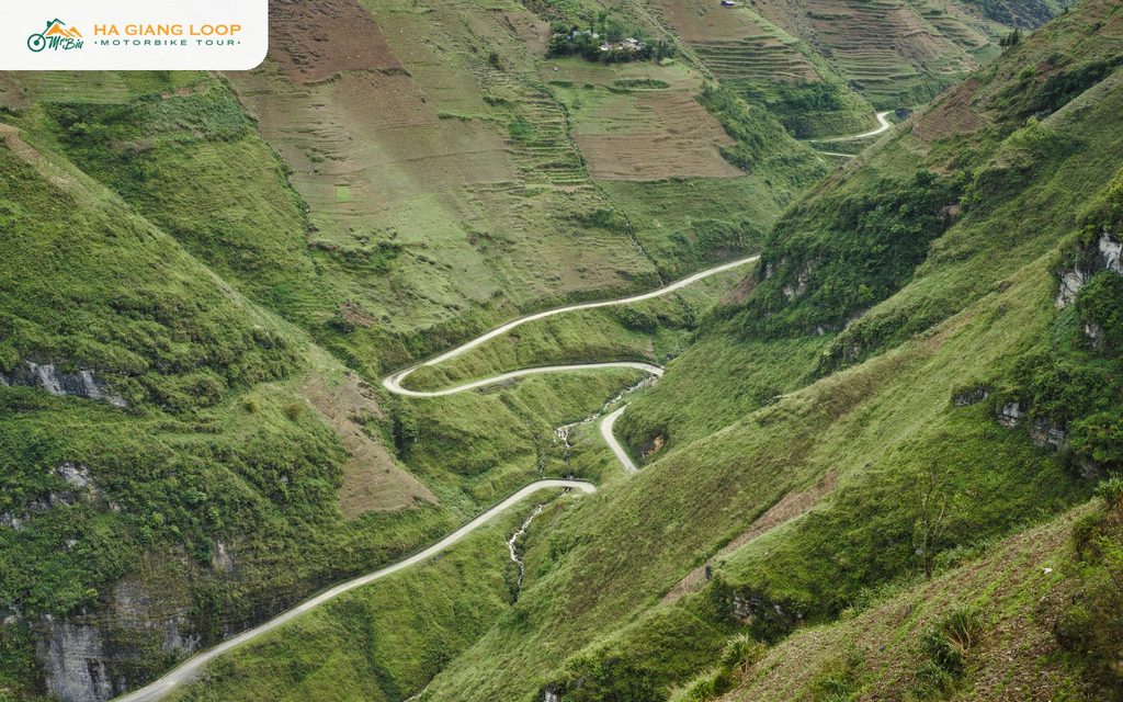 Road winding through a steep green valley at Ma Pi Leng Pass
