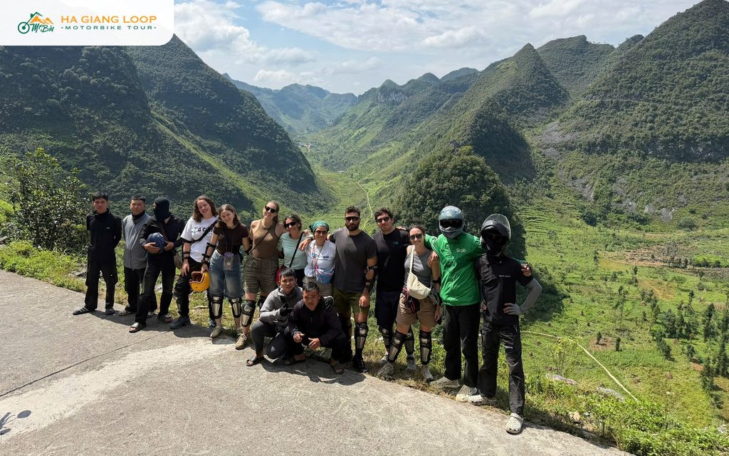 Mr. Biu riders and guides at a photo stop above a green valley
