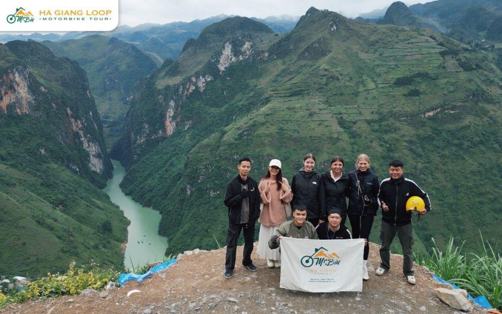 Mr. Biu group holding the company banner above the Nho Que canyon
