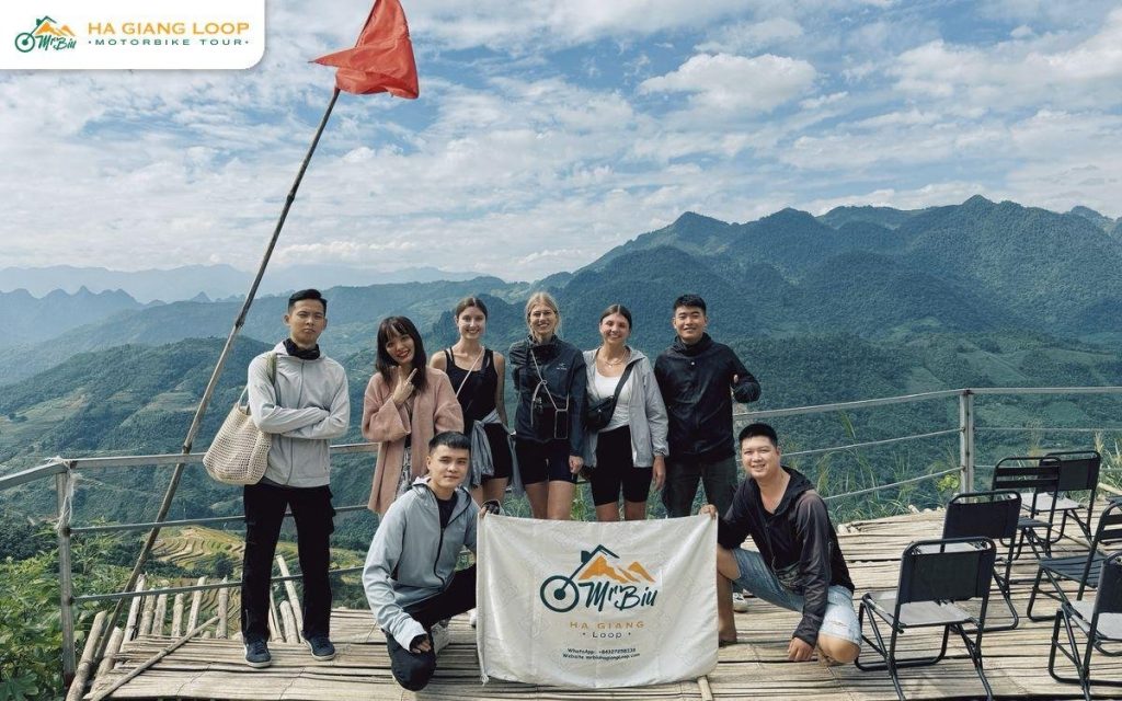 Mr. Biu riders and passengers with the company banner at a viewpoint