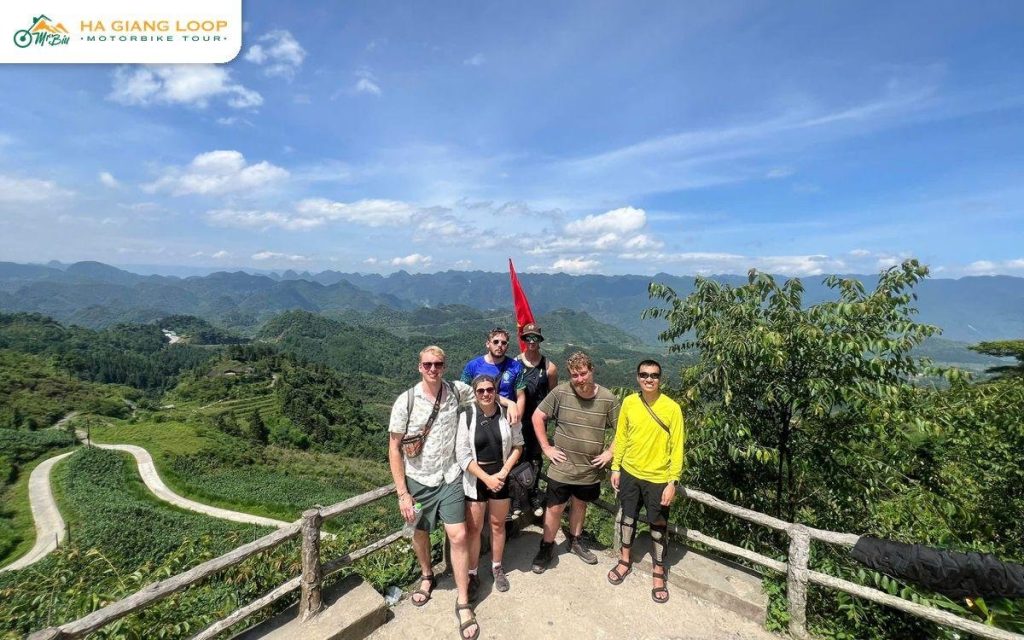 Mr. Biu riders at a roadside viewpoint above winding hairpins