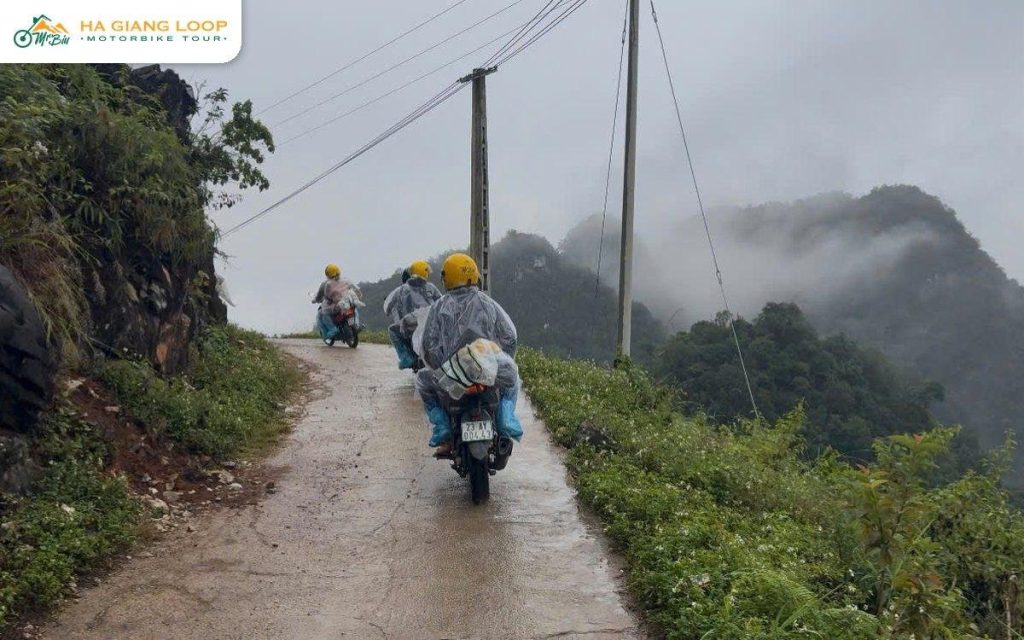 Pillion rider and driver on a wet road through mountain mist