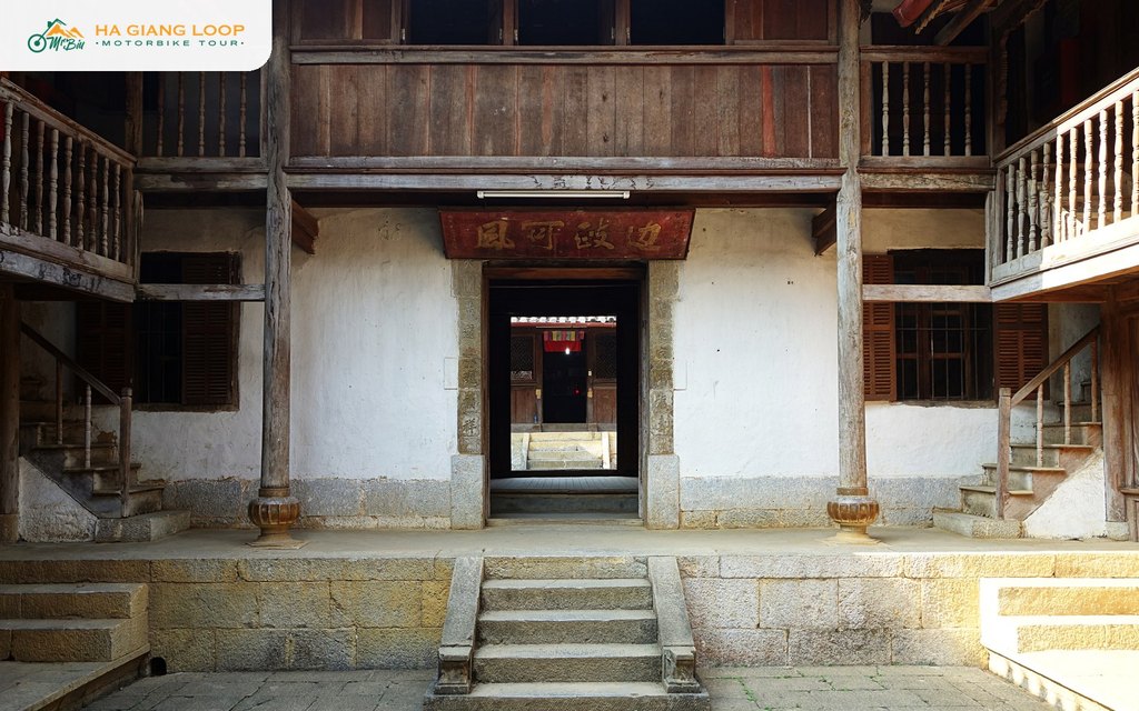 First inner courtyard of the Vuong Family Palace with wooden galleries and stone steps